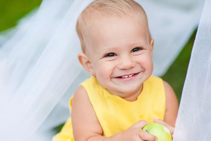Smiling baby picture of child holding apple