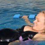 A pregnant lady swimming in a swimming pool