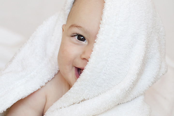 The classic peek-a-boo with a blanket game for 6-month-old baby