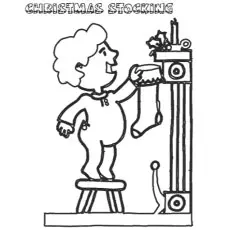 Girl putting up the Christmas stocking coloring page