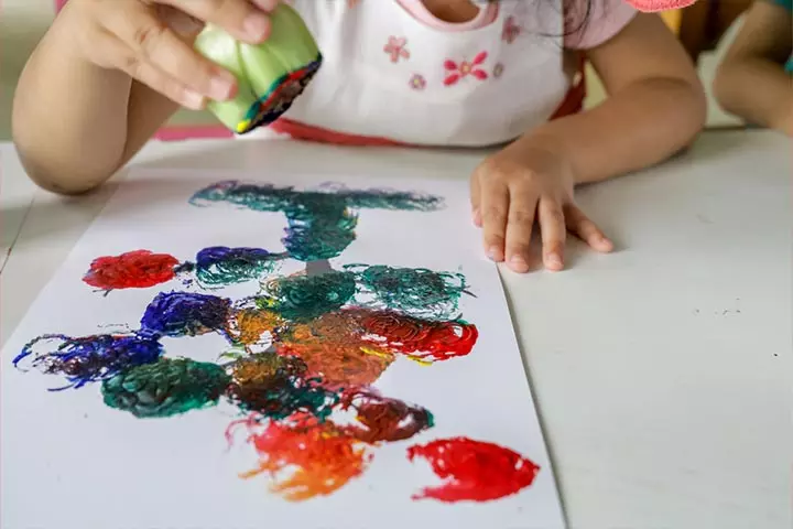 Child painting with Brussels sprouts.