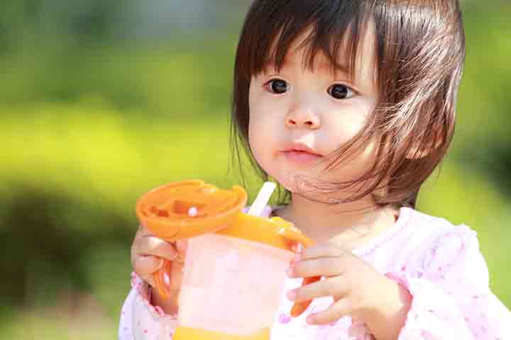 Toddler drinking water through sippy cups