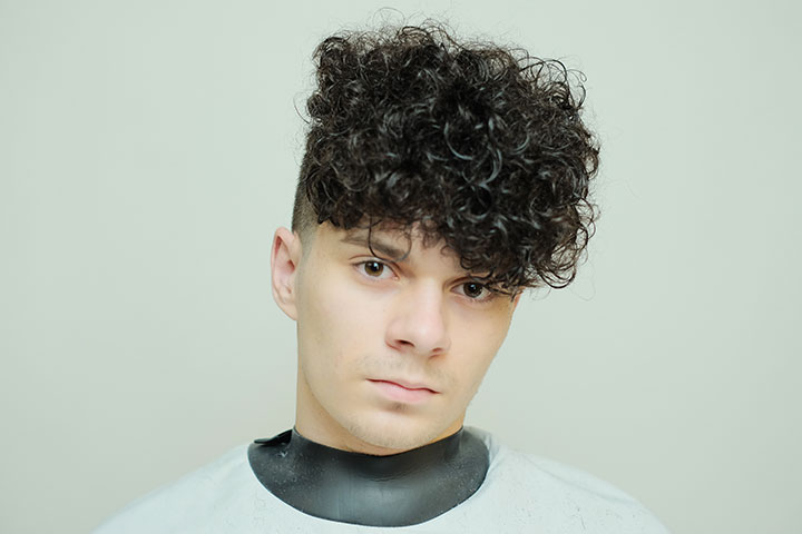 Curly-haired boy with stylish undercut haircut.