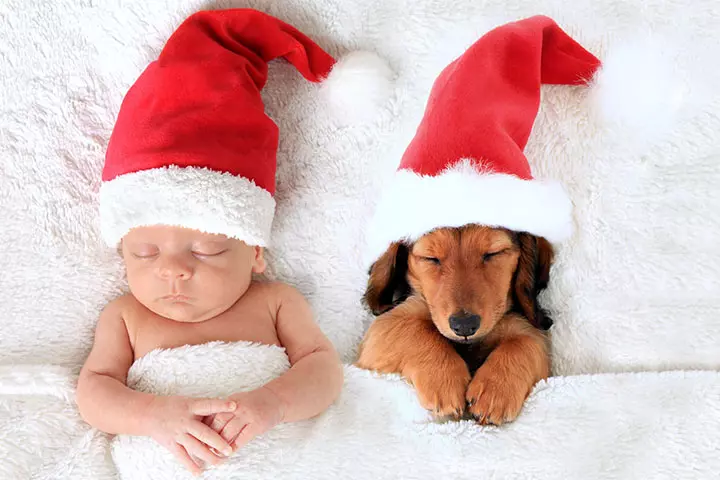 This Christmas baby snuggles in with the Santa puppy