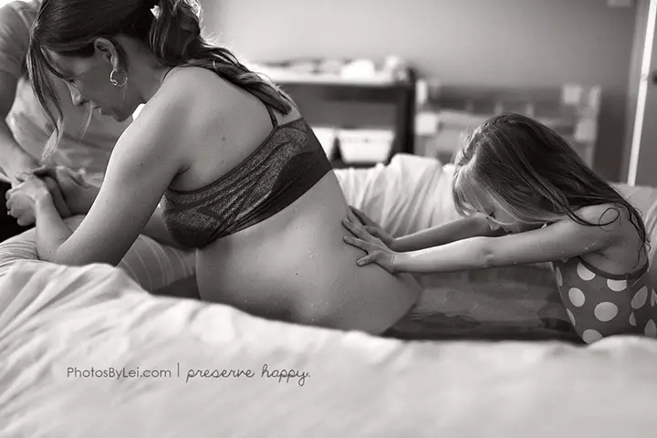 This woman's seven year old is helping her mother by applying pressure on her mother's lower back
