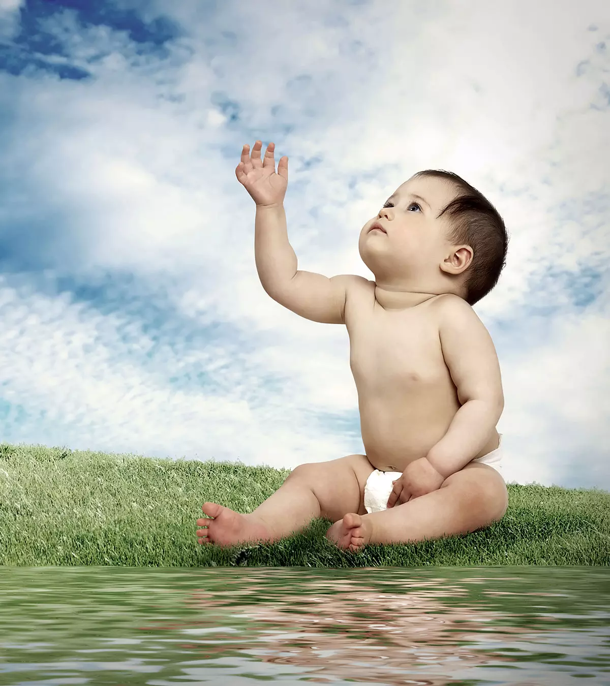 A baby girl holds some grass