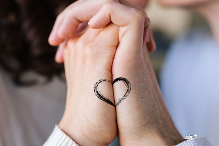 Tiny heart tattoo on hand for couples