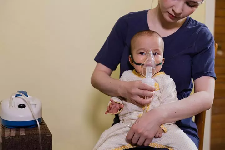 Sit in a comfortable place and hold the baby on your lap in an upright position