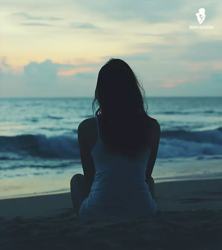 A girl sitting alone on a beach