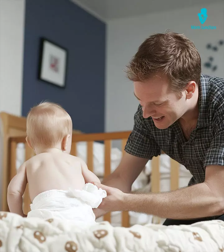 A father changing the diaper of his baby