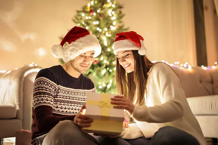 Open gift wearing Christmas caps couple photo pose ideas