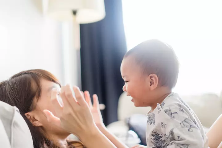 Encourage babies to smile by playing peek a boo.