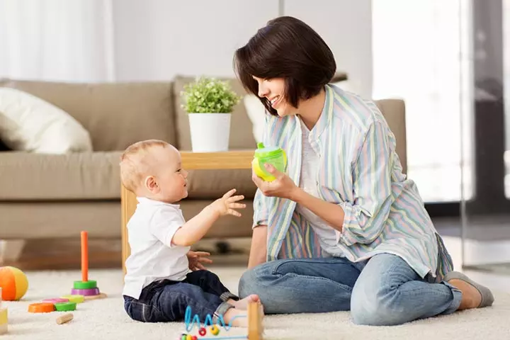 Mother safely playing with baby on a carpet