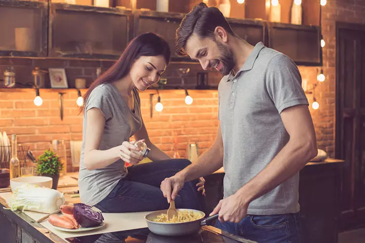 Man helping a woman cook