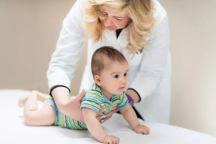 Doctor examining Symmetric tonic neck reflex in babies