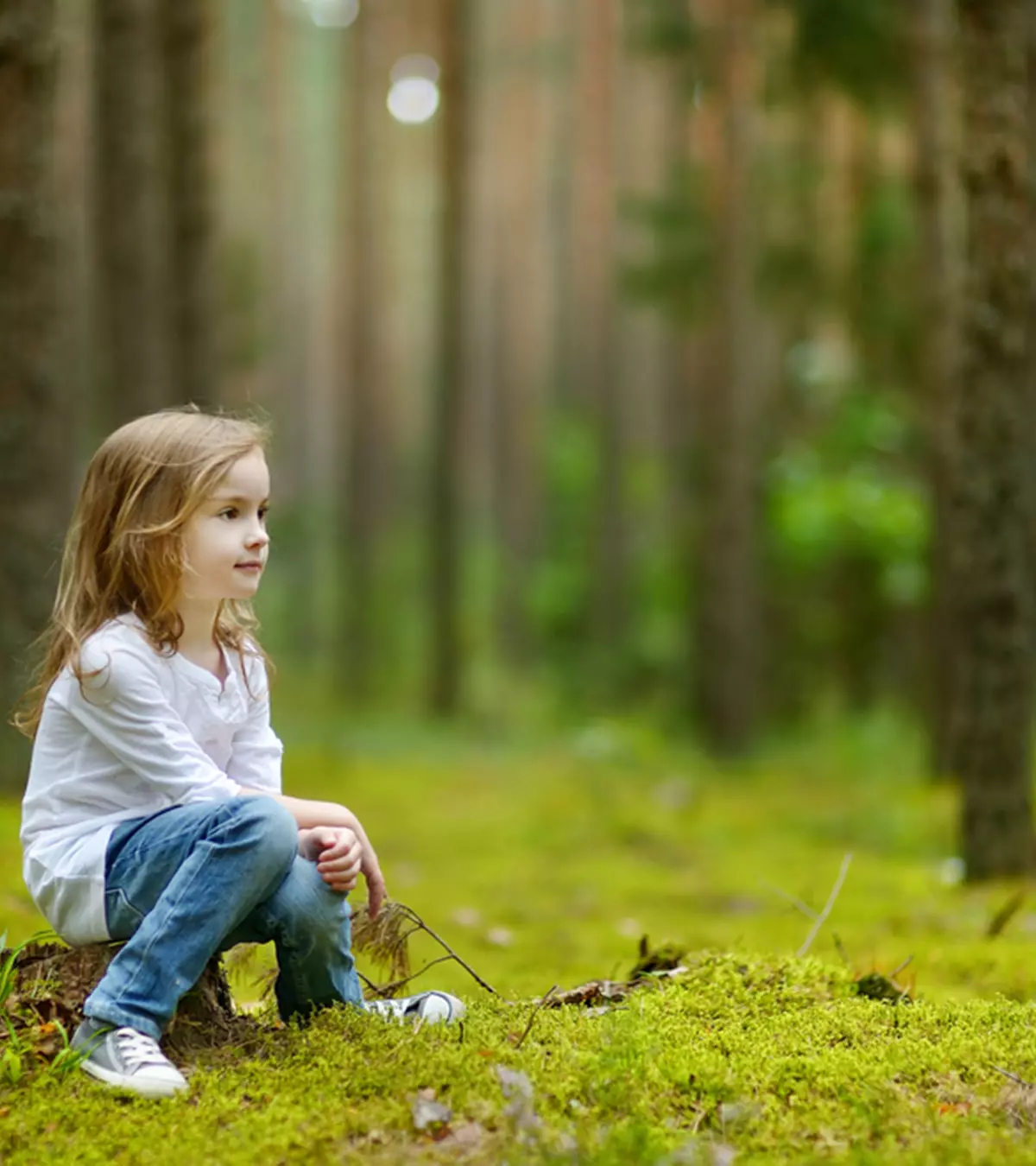 A kid sitting in the forest