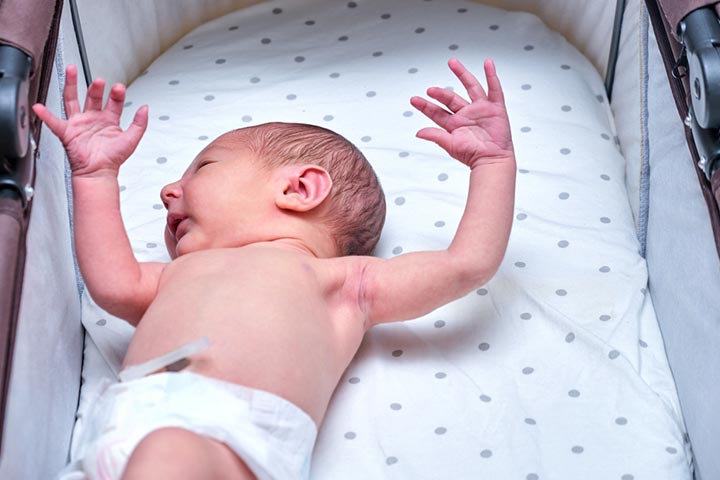 The baby reacts to a loud noise by extending legs, arms, and neck.
