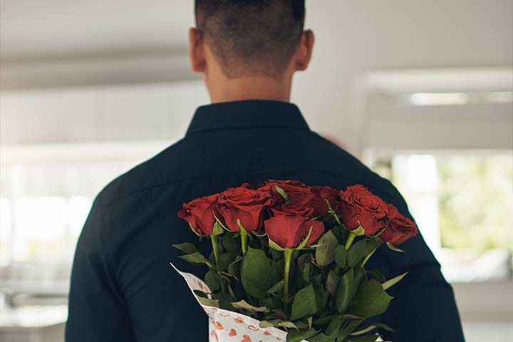 Man brings a bouquet of roses for his wife