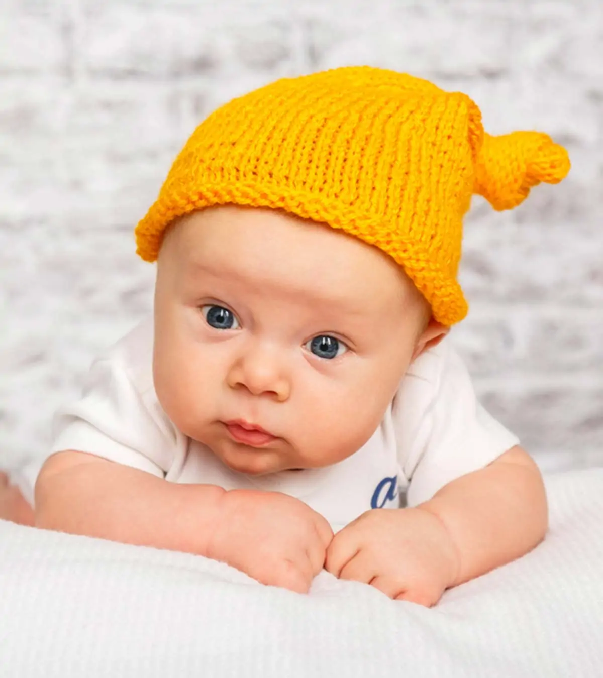 A small baby in a yellow hat