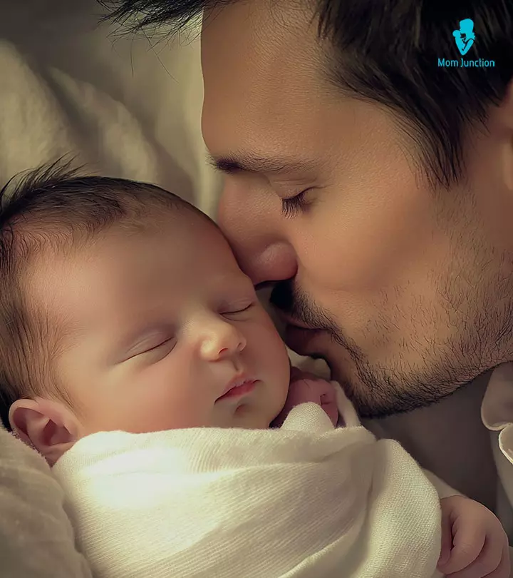 A dad kissing his newborn baby