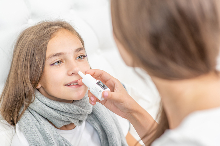 Gently administering nasal spray for kids