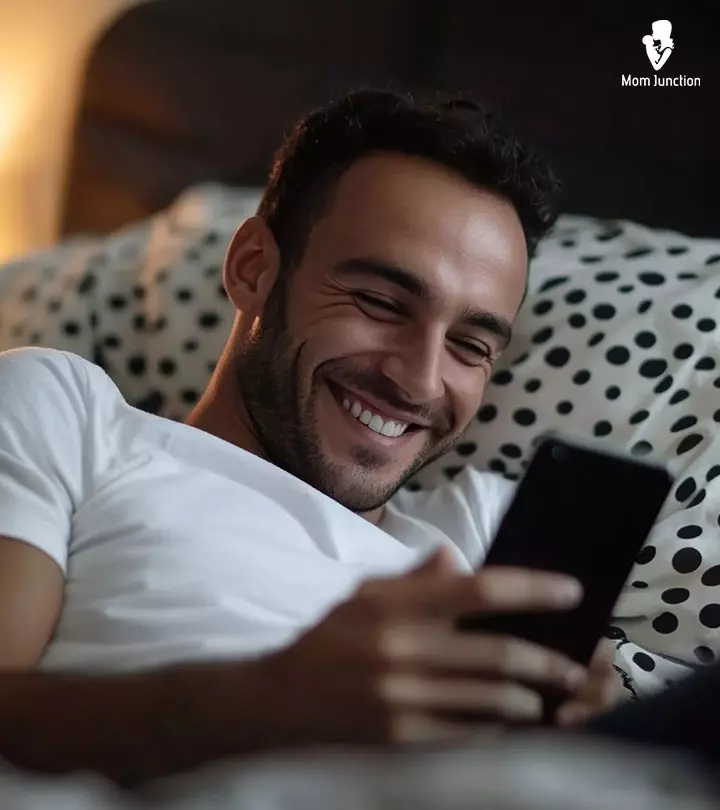 A Man Looking At Phone And Smiling