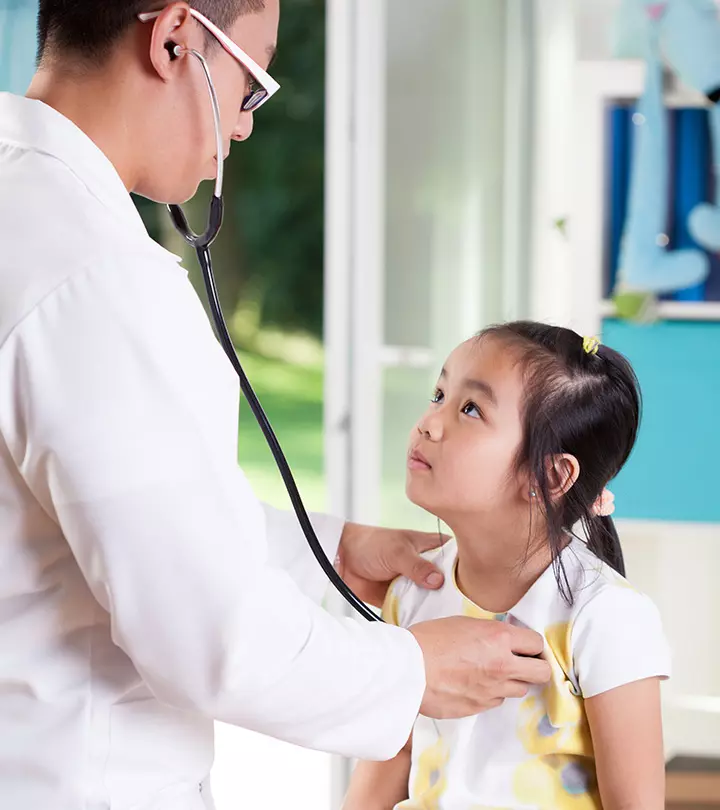 A doctor checking a little girl's heartbeat