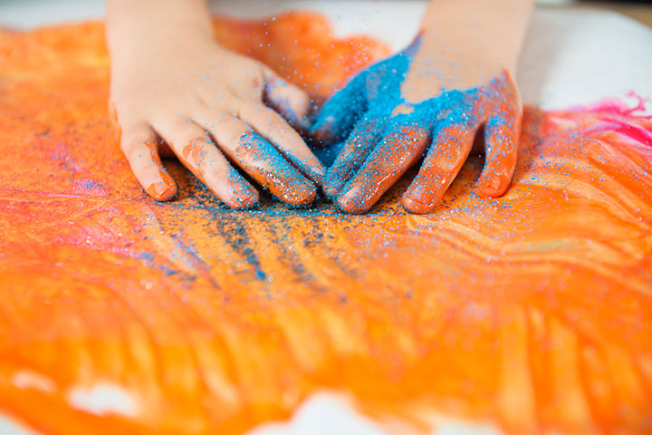 Different-textured paints such as glitter, sand, and sequins finger paint for toddlers
