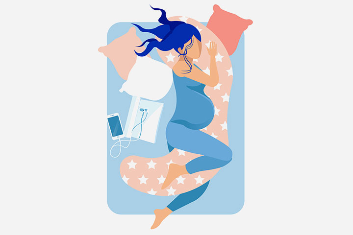 A pregnant woman sleeps on a pregnancy pillow