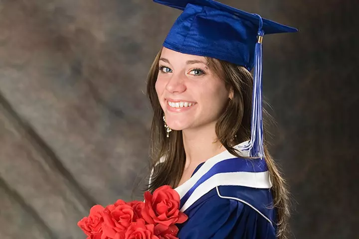 Graduate girl with flowers smiling