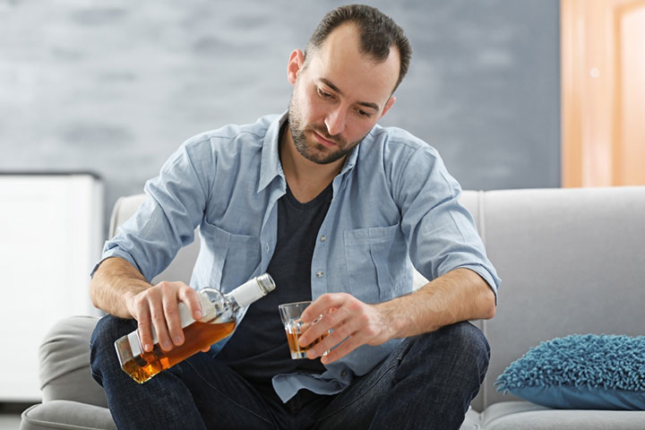 Man drinking, signs he is hurting after breakup