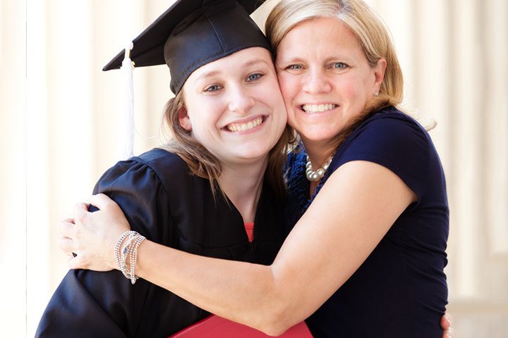 Mother hugging graduate daughter