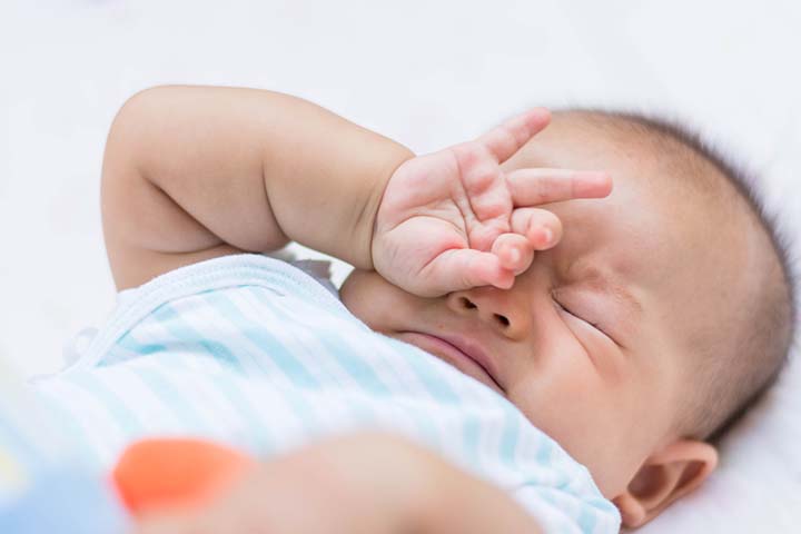 A sleepy baby may begin rubbing their eyes