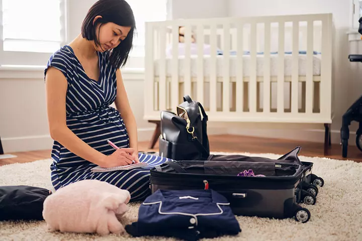 Pregnant woman listing things to pack for herself