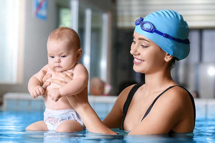 Hold the baby while teaching swimming