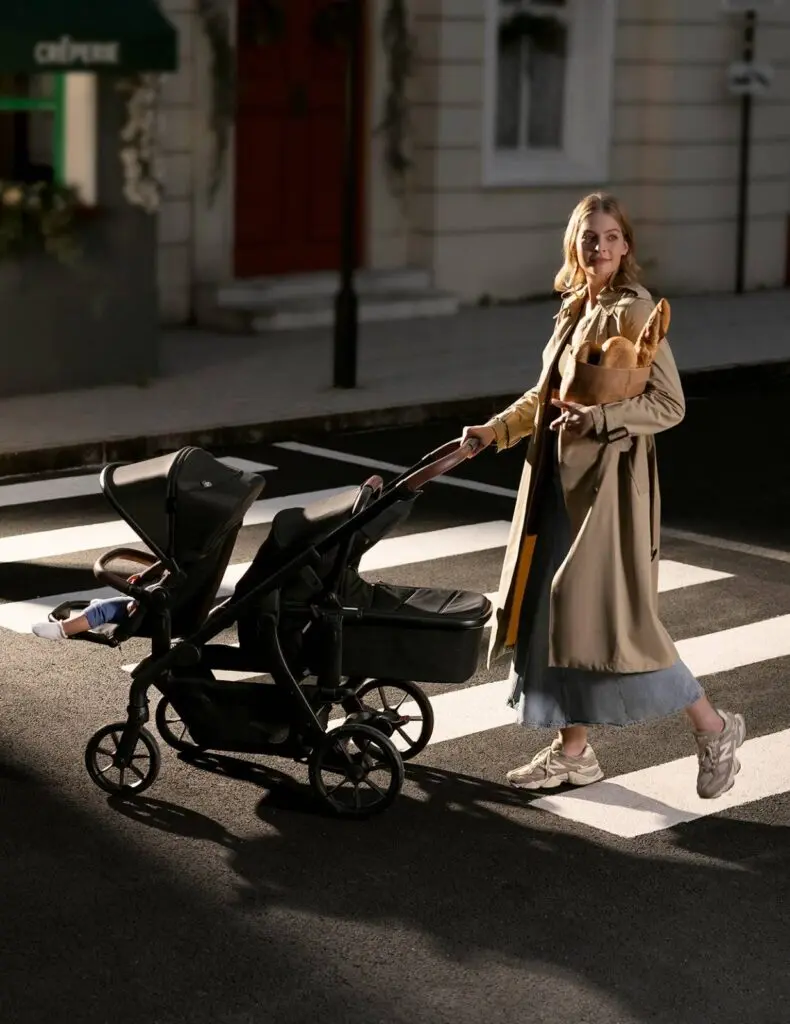A mother using the Momcozy ChangeGo Stroller in the wagon mode during a grocery run.
